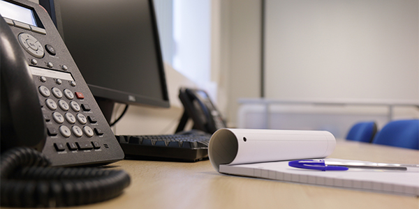 Phone with notepad on desk